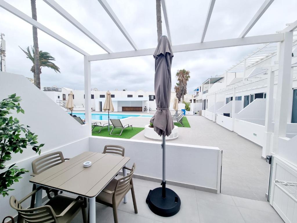 a patio with a table and an umbrella at Luxury Zen Puerto Del Carmen in Puerto del Carmen