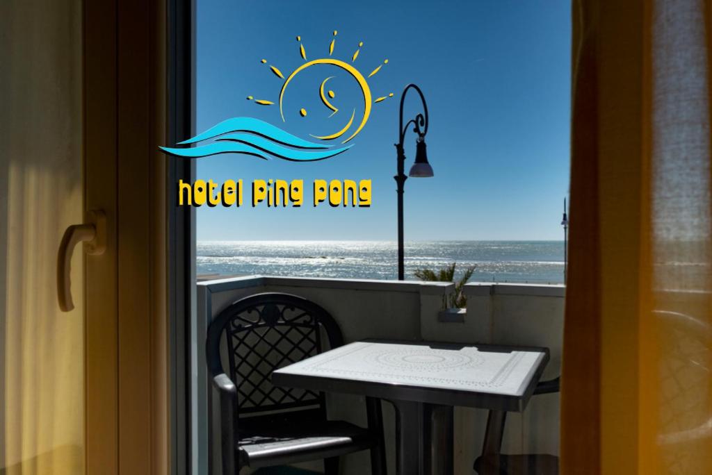 a table and a window with a table and the ocean at Hotel Ping Pong in Lido di Ostia
