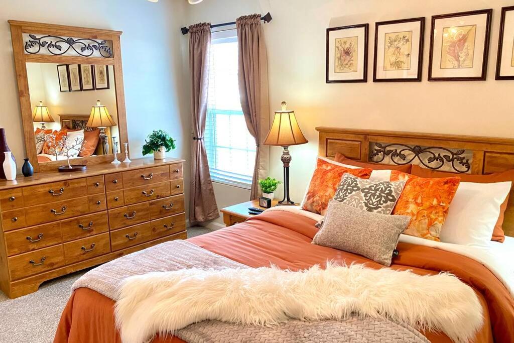 een slaapkamer met een groot bed en een dressoir bij Spacious & comfy home in ultra-convenient location in Winder