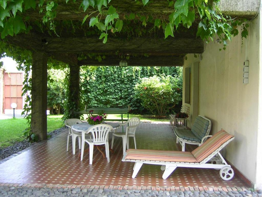 un patio con mesa, sillas, mesa y sillas en Villa Arya Casa Vacanza, en Riposto