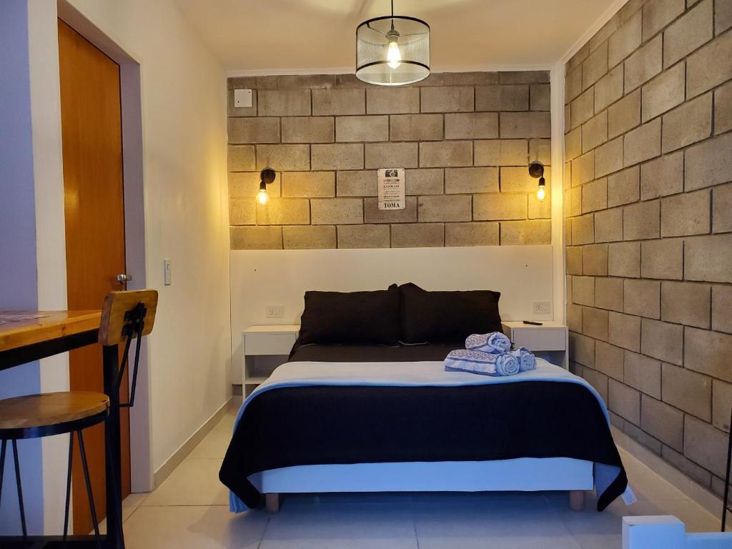 a bedroom with a bed and a brick wall at Suite NY, depto a estrenar -15 min Aerop in Monte Grande