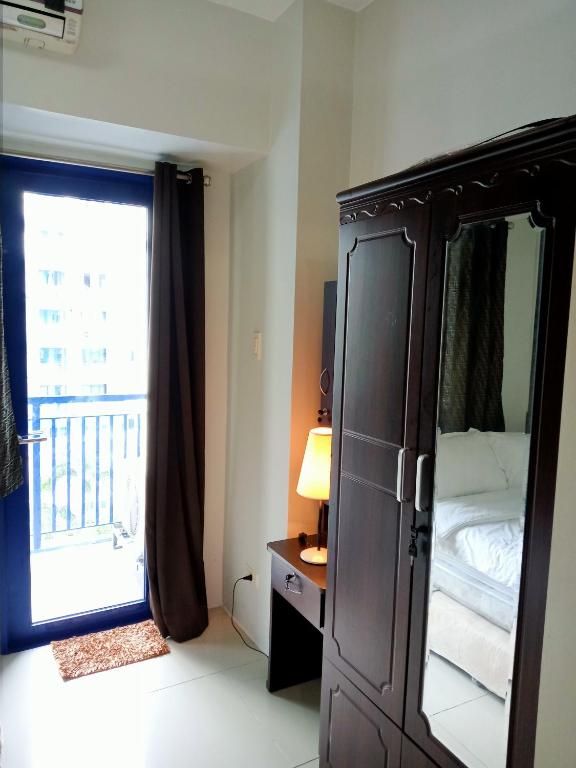 1 dormitorio con 1 cama, vestidor y ventana en SEA RESIDENCES F en Manila