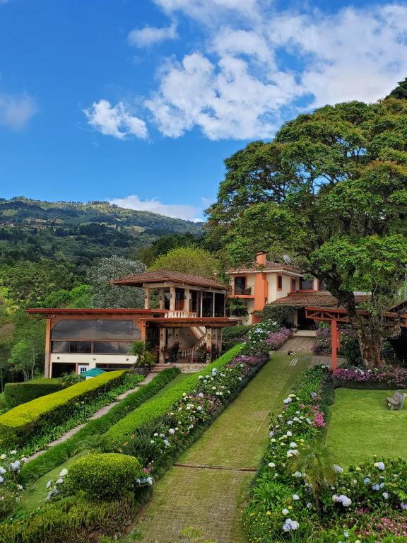 Elle offre une vue sur une maison avec un jardin. dans l'établissement Finca Paraiso Mountain Retreat near San Jose Airport, à Birrí