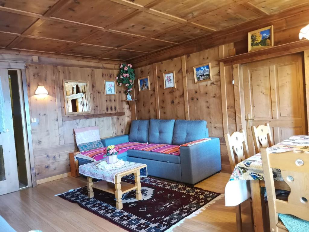 a living room with a couch and a table at Appartamento Col di Lana Dolomites in Livinallongo del Col di Lana