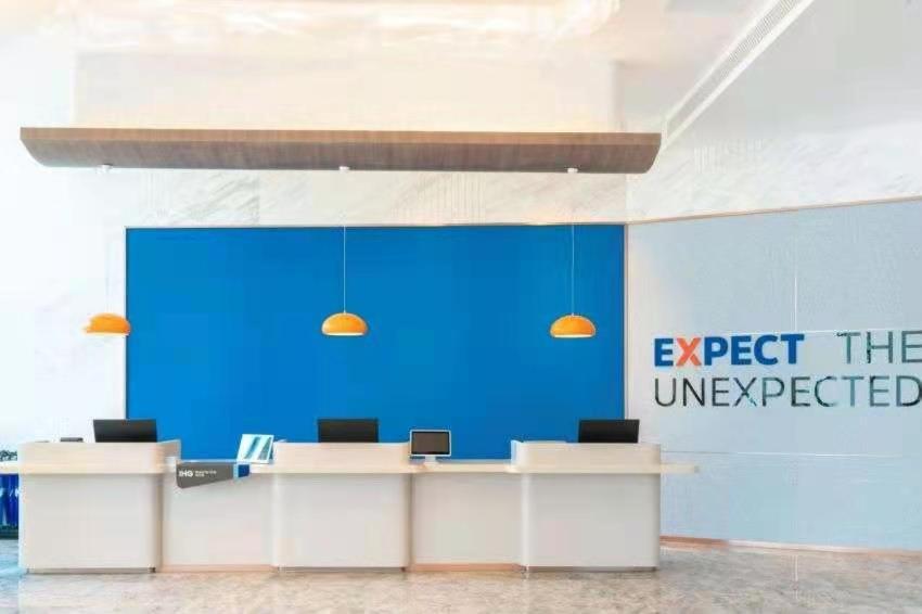 an office with two desks and a blue wall at Holiday Inn Express Xining Railway Station, an IHG Hotel in Xining