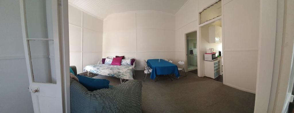 a small room with a bed and a blue table at Golden Mount Rest Townside in Mount Morgan