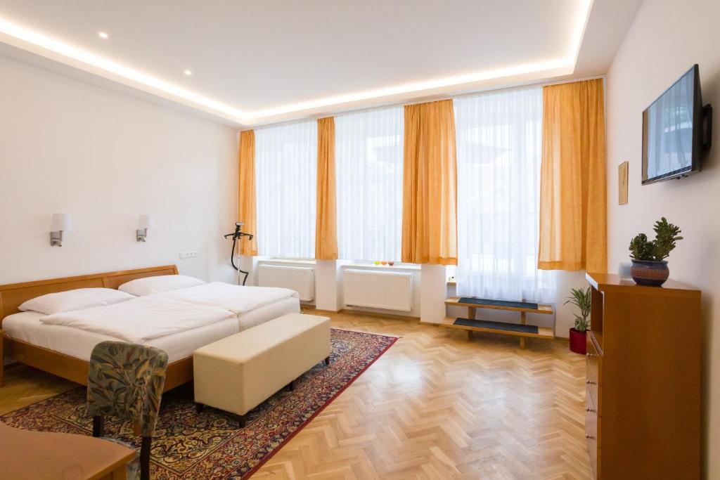 1 dormitorio con cama, sofá y ventanas en Luxusní velký apartmán s terasou v centru Litomyšle, en Litomyšl