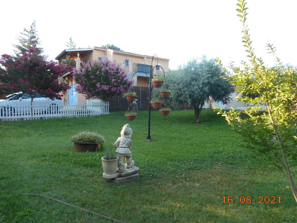 a statue of a girl standing in a yard at Le Rieufroid in Malaucène