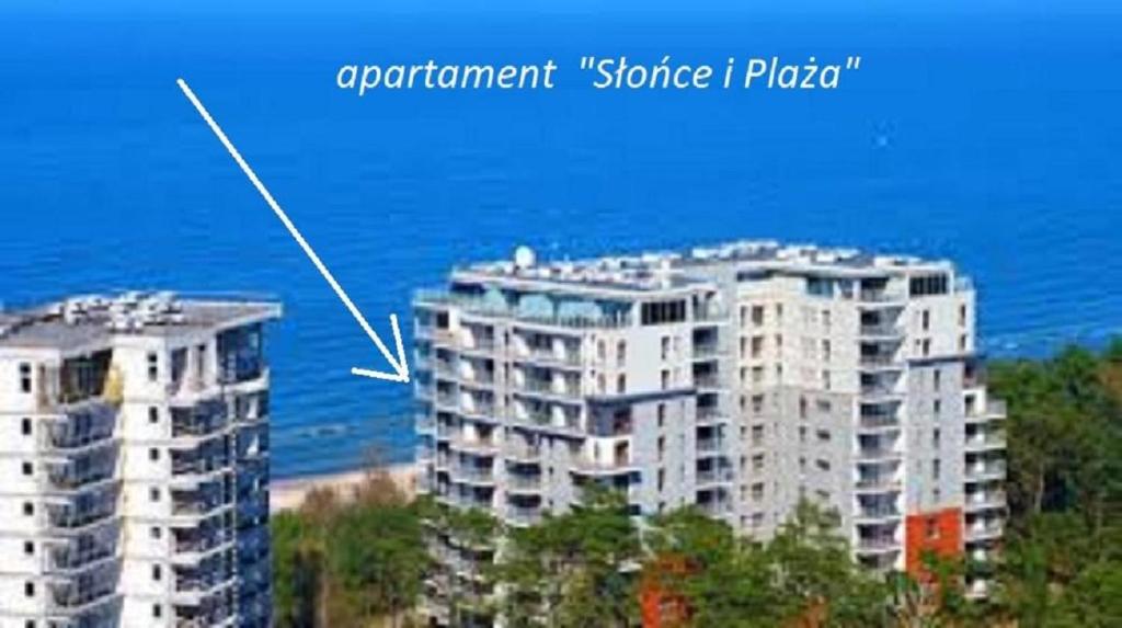 duży biały apartamentowiec nad oceanem w obiekcie Apartament nad morzem Słońce i Plaża w Dziwnówku