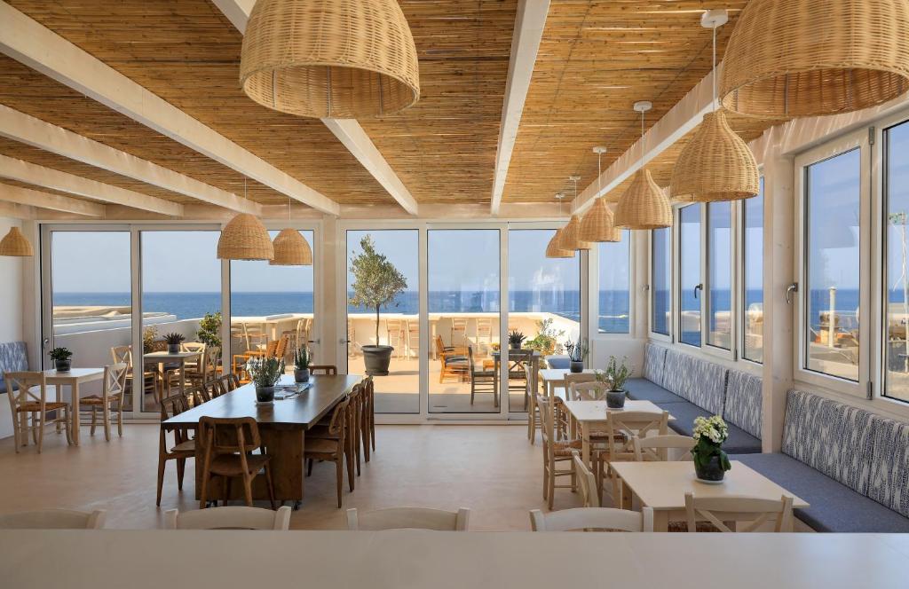 
a dining room with tables and chairs and a large window at Sea Breeze Hotel in Hersonissos
