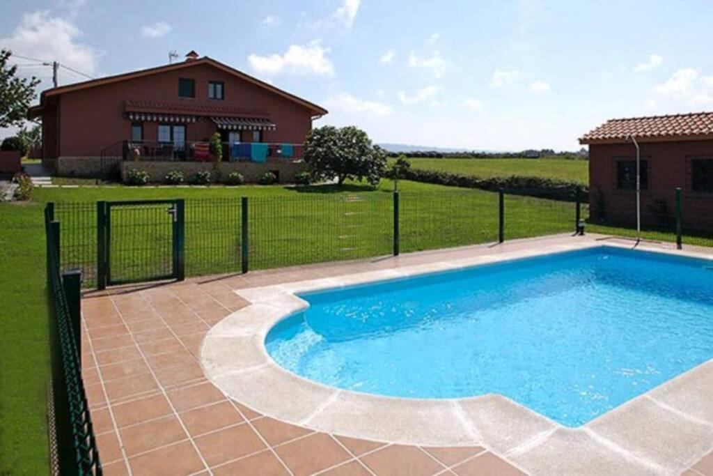 una piscina in un cortile accanto a una casa di Villa Brandán - Villa con piscina privada para 12p a Villaviciosa