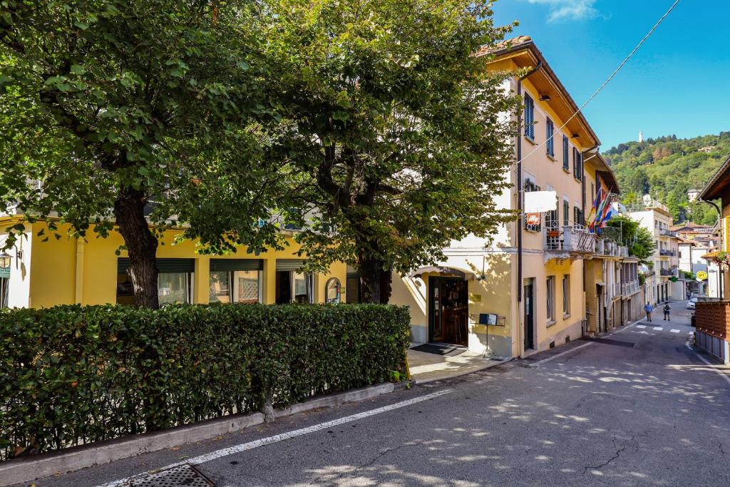 una calle en una ciudad con un edificio amarillo en Locanda Milano 1873, en Brunate