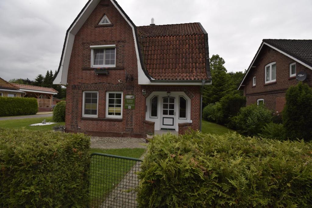 ein braunes Backsteinhaus mit weißer Tür in der Unterkunft Ferienhaus Dorfkind in Bülkau