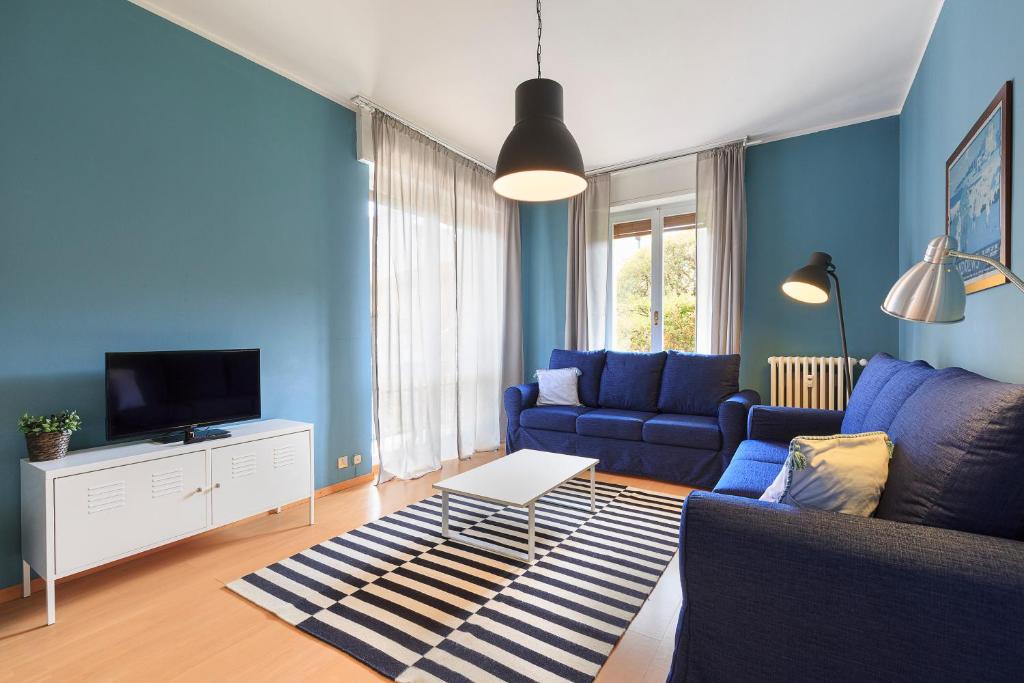 niebieski salon z kanapą i telewizorem w obiekcie Diana - By Impero House w mieście Stresa