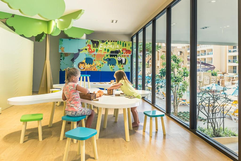 zwei Kinder, die an einem Tisch in einer Kindergarten-Cafeteria sitzen in der Unterkunft Pamookkoo in Kata Beach