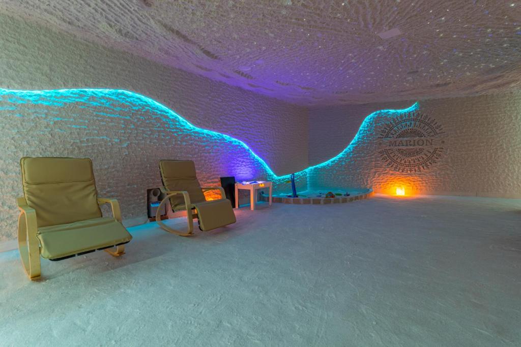 a room with two chairs and a wall with blue lights at MARION SPA Hotel & Spa - RENOVATION - Rooms, SPA area, Swimming pool, Reception, Restaurant, Lounge Bar, Hookah bar, Children's room, Parking, SPA and Breakfast included in the price in Bukovel