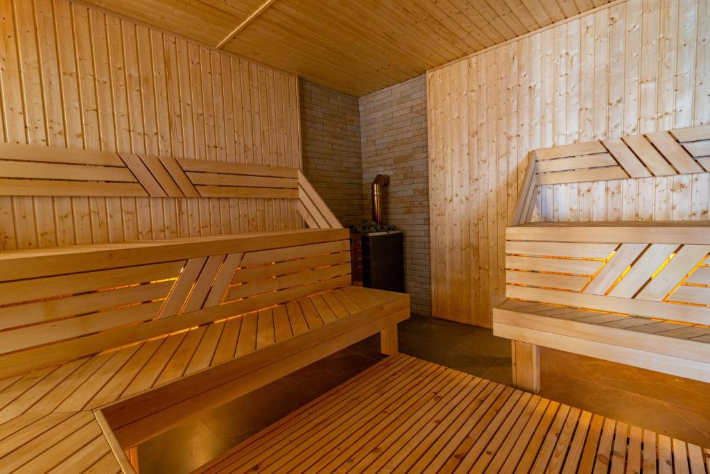 a sauna with two wooden benches in a room at MARION SPA Hotel & Spa - RENOVATION - Rooms, SPA area, Swimming pool, Reception, Restaurant, Lounge Bar, Hookah bar, Children's room, Parking, SPA and Breakfast included in the price in Bukovel