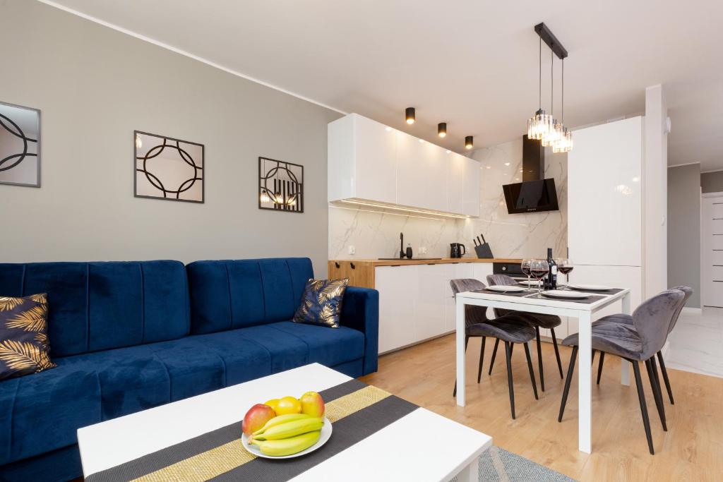 een woonkamer met een blauwe bank en een tafel bij Beautiful Two-Bedroom Apartment Warsaw Bielany by Renters in Warschau