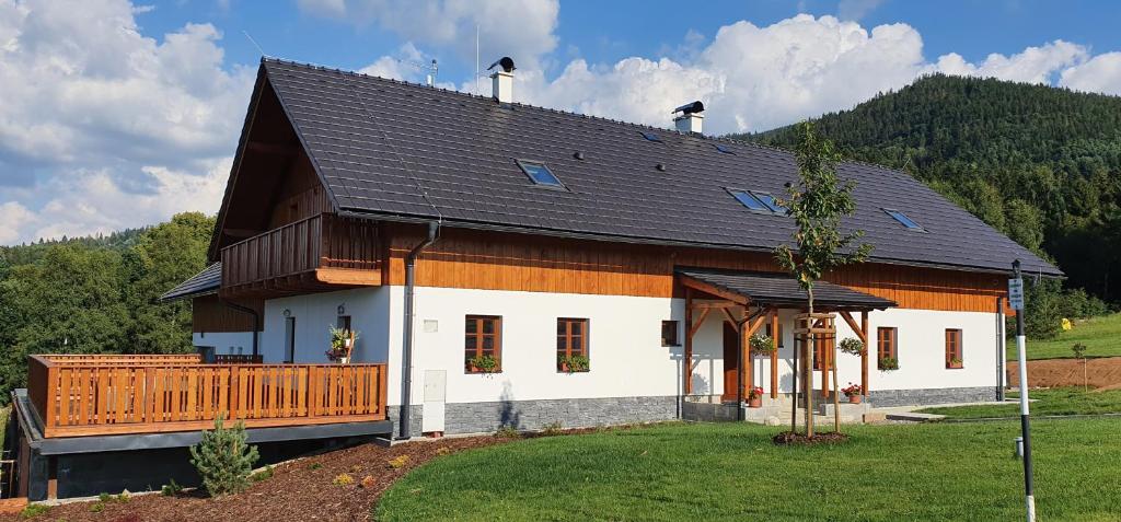 uma grande casa branca com um telhado preto em Penzion Stříbrník em Krásná