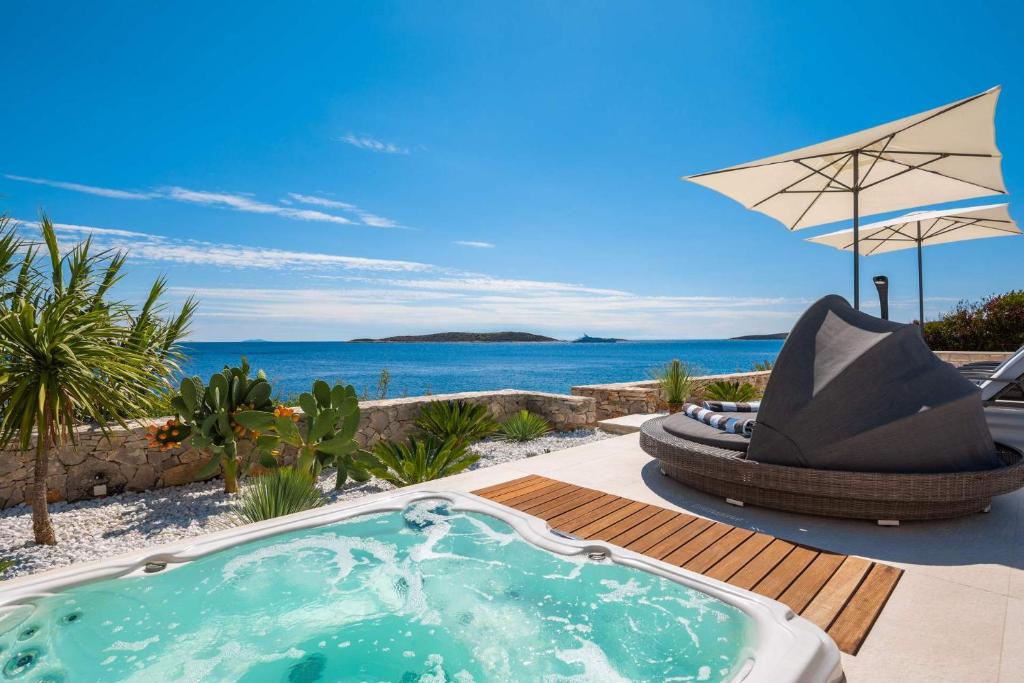 uma banheira de hidromassagem num pátio com vista para o oceano em Villa Carisma island Vis em Vis