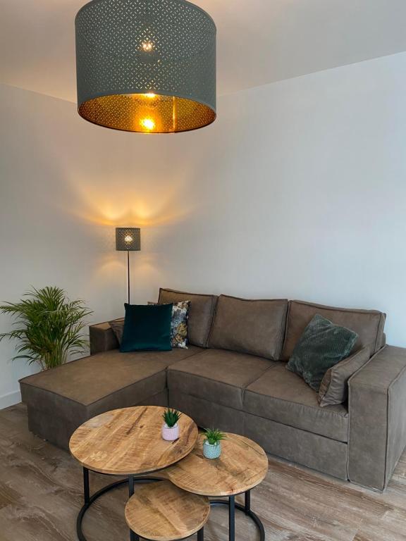 a living room with a couch and two tables at Appartement aan de Mergelgrot -Cauberg Valkenburg in Valkenburg
