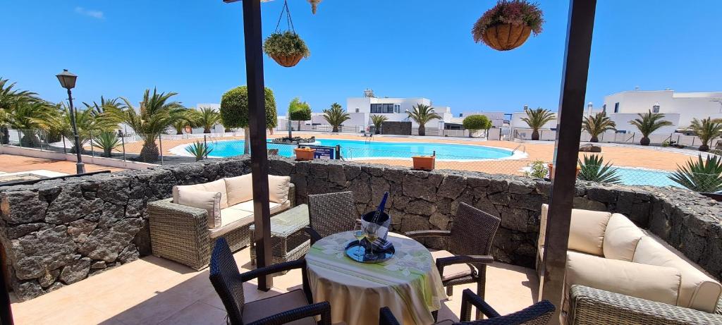 un patio con tavolo, sedie e piscina di Casa Aitana a Puerto Calero