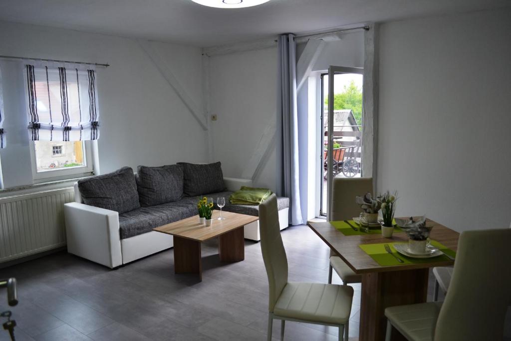 ein Wohnzimmer mit einem Sofa und einem Tisch in der Unterkunft Ferienwohnung Klüger in Liebstadt