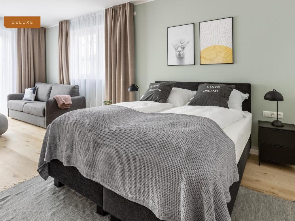 um quarto com uma cama grande e um sofá em limehome Osnabrück Johannisstraße em Osnabrück