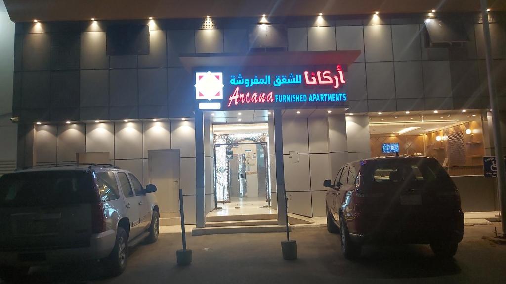 two cars parked in front of a garage at night at أركانا للشقق المخدومة in Tabuk
