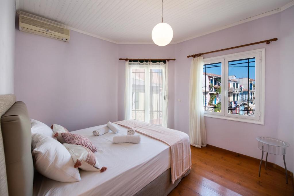 biała sypialnia z łóżkiem i oknem w obiekcie Ionian Grand - Apartments w mieście Leukada (miasto)