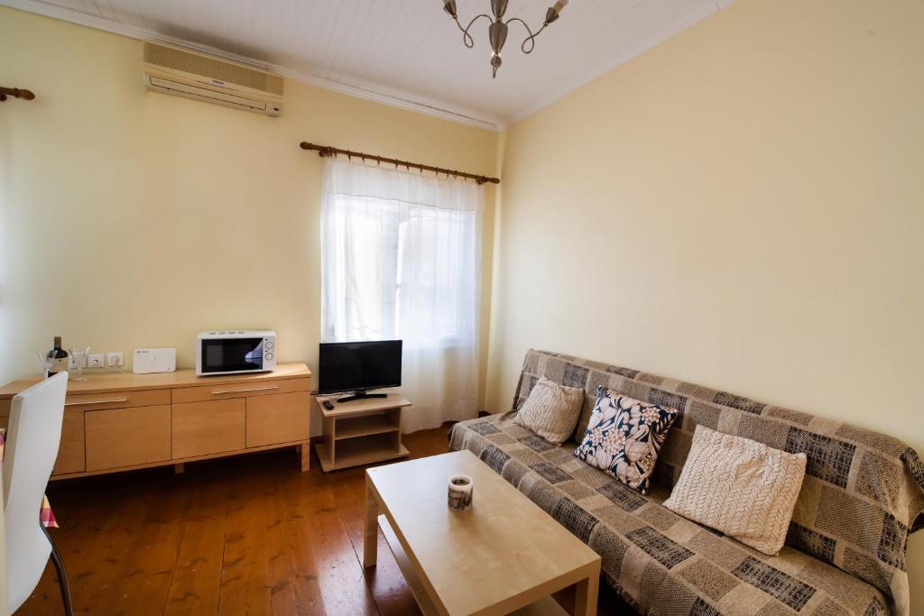 salon z kanapą i telewizorem w obiekcie Ionian Grand - Apartments w mieście Leukada (miasto)