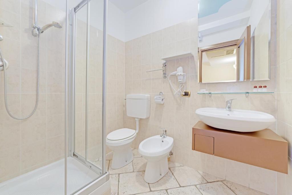 a bathroom with a toilet and a sink and a shower at Hotel Grotto Bagat in Lavena Ponte Tresa
