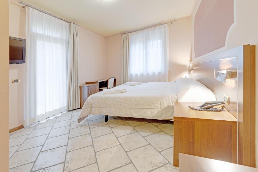 a hotel room with a bed and a sink at Hotel Grotto Bagat in Lavena Ponte Tresa