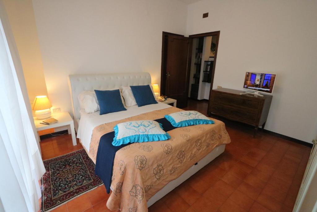 a bedroom with a bed with blue pillows on it at Bari Suite Apartment Barone 12 in Bari