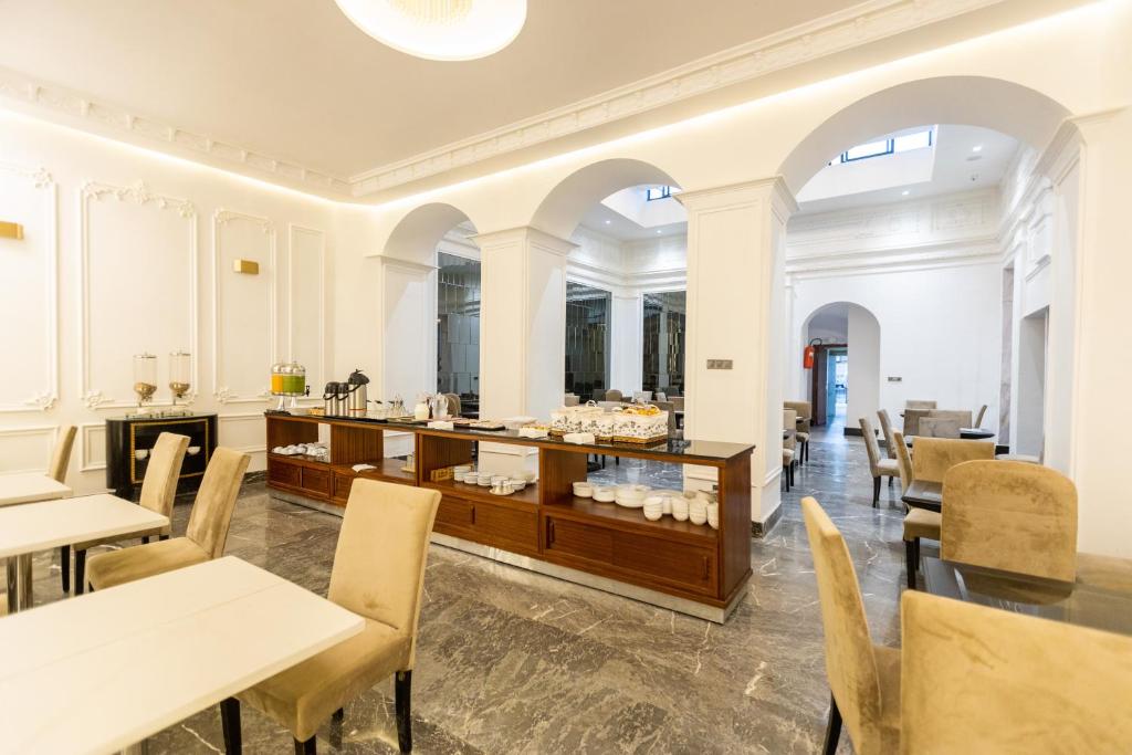 a restaurant with tables and chairs and a counter at Hotel Majestic in Casablanca