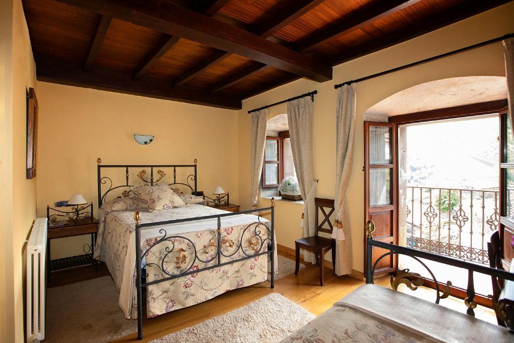 a bedroom with a bed and a large window at La Casona de Lombraña, en Polaciones (Saja-Nansa) in Lombraña