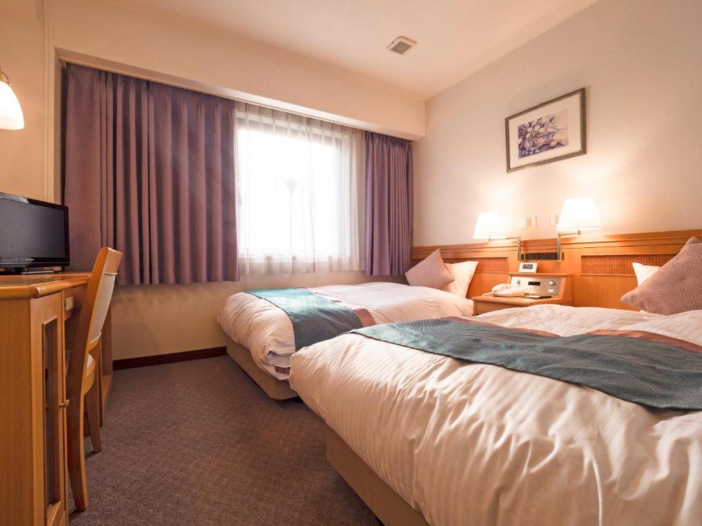 Postel nebo postele na pokoji v ubytování Hotel Areaone Wadayama