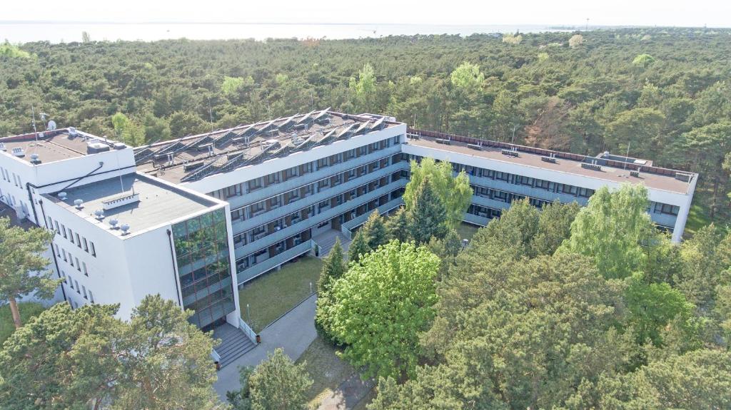 an overhead view of a white building with trees at Ośrodek Delfin Rewita in Jurata