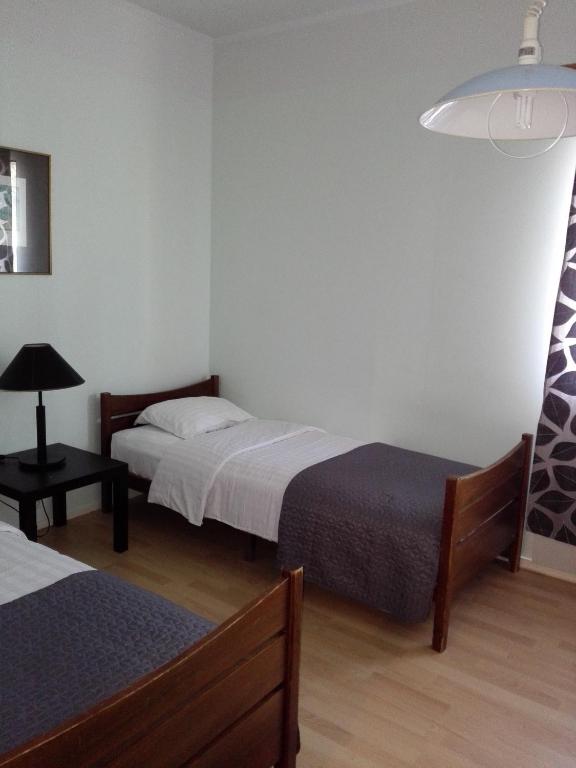 een kamer met 2 bedden en een lamp bij Motelli Karjala in Uimaharju