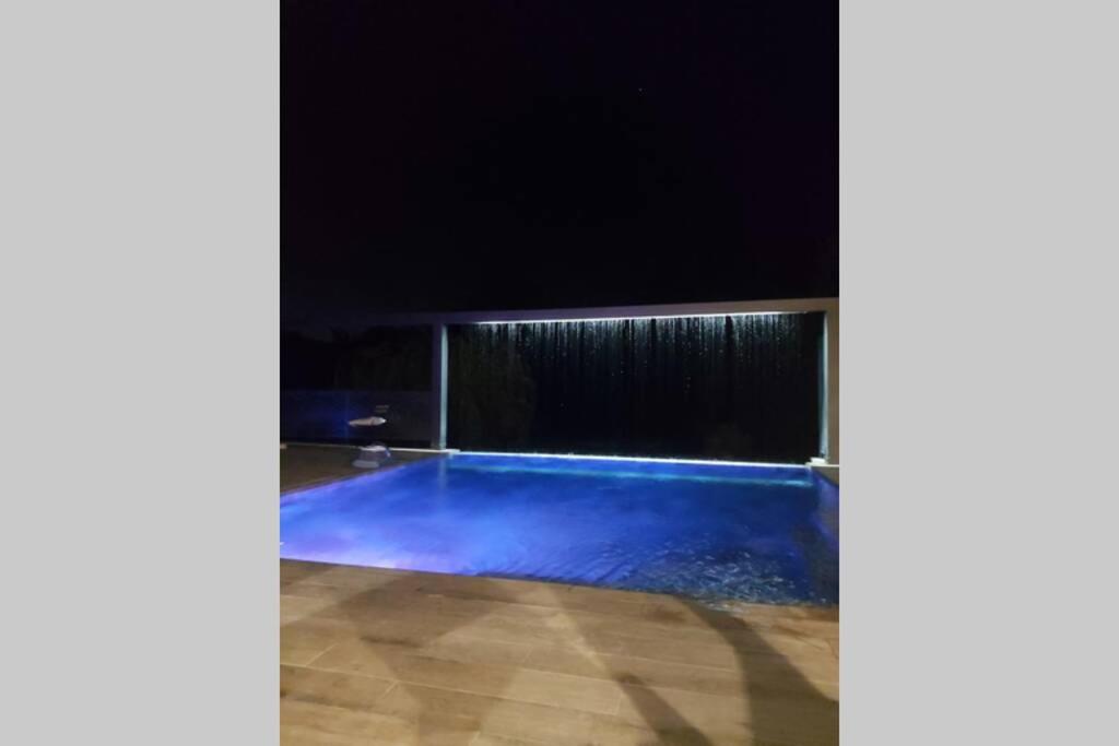 una piscina en una habitación por la noche en Un petit coin de Bali avec SPA et piscine privés, en Carpentras