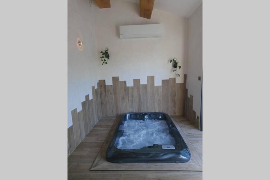 - un bain à remous dans l'angle de la chambre dans l'établissement Un petit coin de Bali avec SPA et piscine privés, à Carpentras