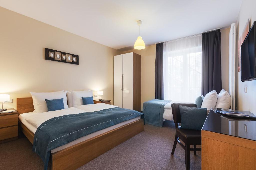 漢堡的住宿－漢堡新城區豪爾斯登諾富姆酒店，酒店客房设有一张床、一张书桌和一台电视机。