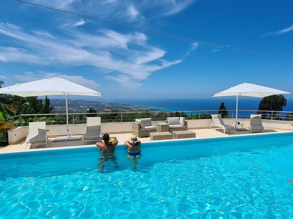 duas pessoas estão numa piscina em Villa Zufrò em Vibo Valentia