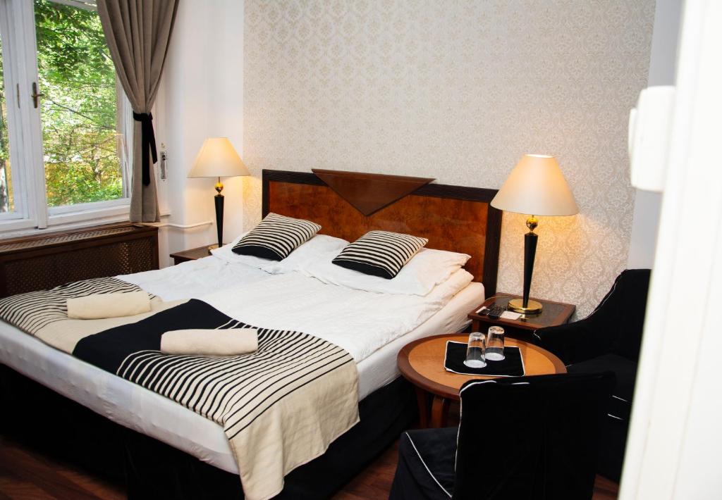 a bedroom with two beds and a table with a chair at Evergreen Budapest Guest House in Budapest