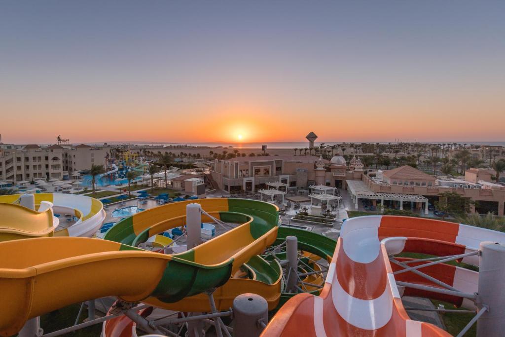 eine Gruppe Rutschen in einem Wasserpark bei Sonnenuntergang in der Unterkunft Pickalbatros Aqua Park Resort - Hurghada in Hurghada