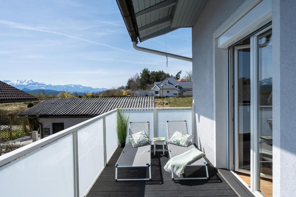 韋爾特湖畔費爾登的住宿－Schönes Ferienhaus mit Garten，阳台配有2把椅子和桌子