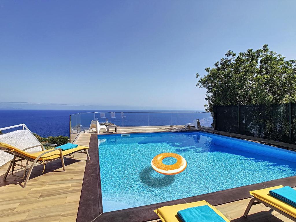 una piscina con un frisbee de naranja en el agua en Viela Vie by LovelyStay, en Caniço