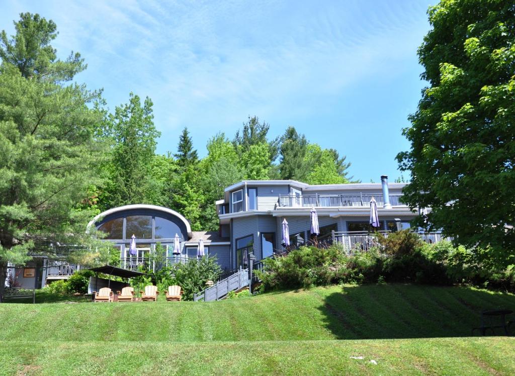 una gran casa azul con césped delante en La Petite Auberge de Jouvence, en Magog-Orford