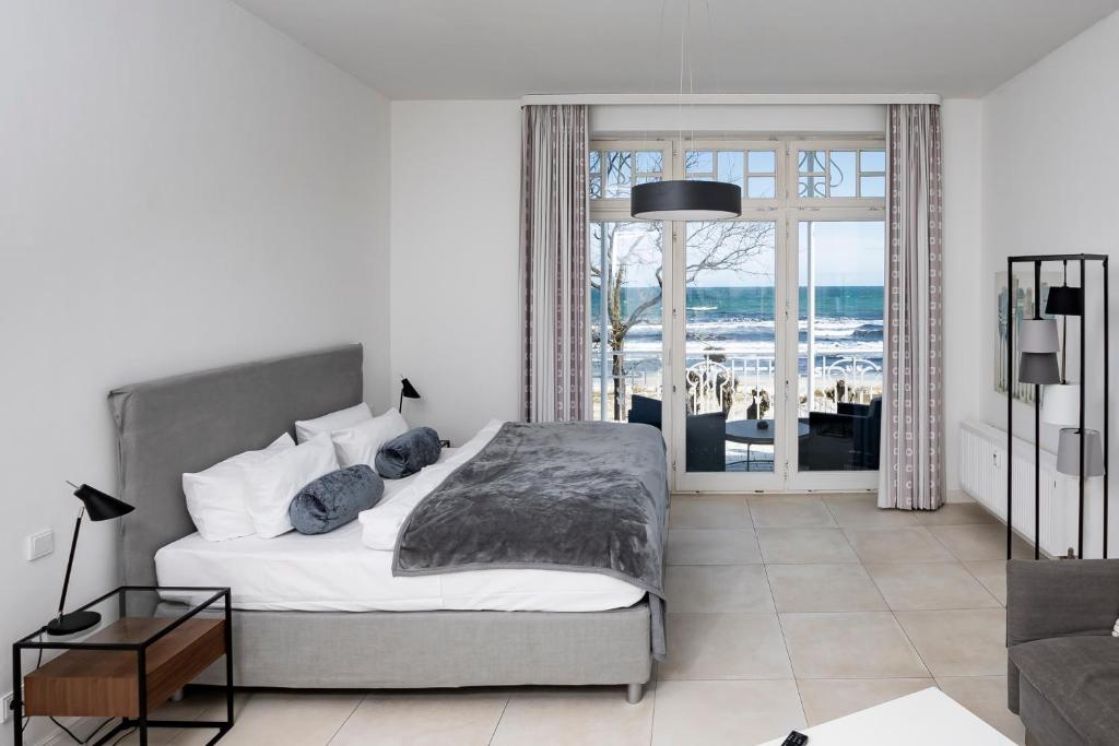 a bedroom with a bed and a view of the ocean at Appartementhaus Bellevue Binz in Binz