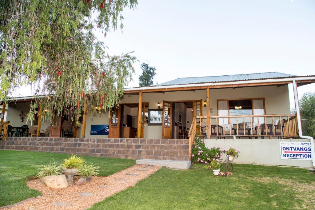 une maison avec un panneau devant elle dans l'établissement Sandy's Place, à Barrydale